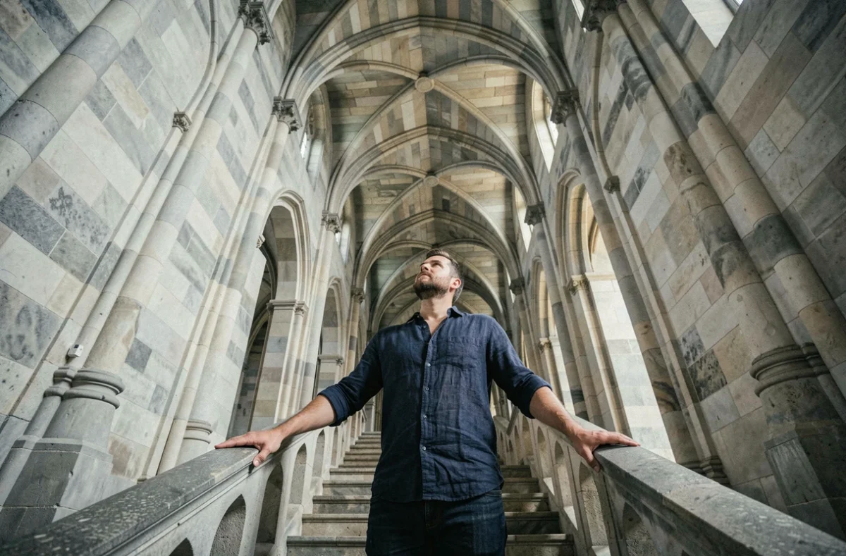 Homme contemplant un escalier architectural dans une cathédrale en lien avec le symbole de l'Échelle de Jacob